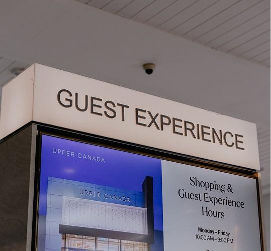 Illuminated Guest Experience sign above the Upper Canada information desk