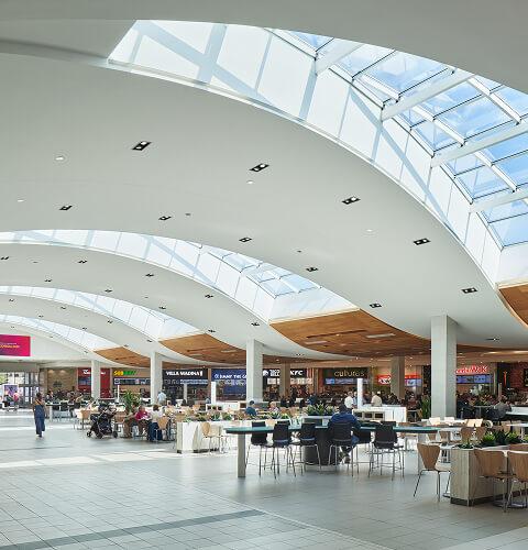 Busy mall food court under skylights with Villa Madina, KFC and A&W