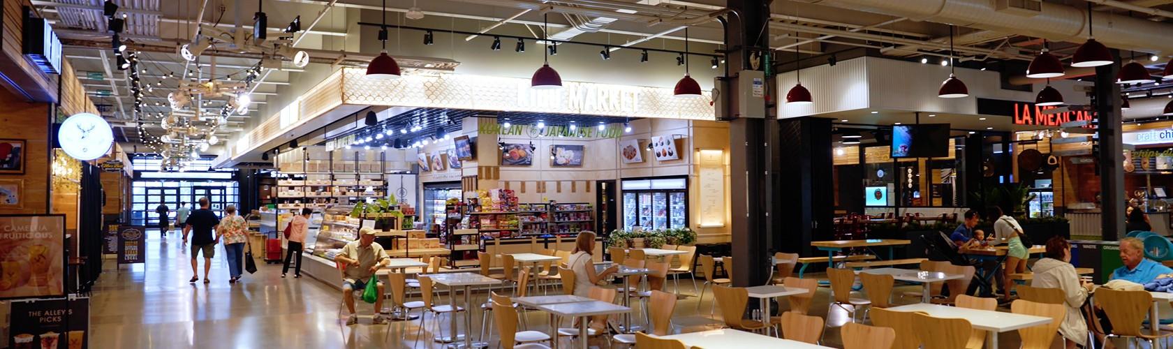 Interior of the Market & Co. food hall with dining tables and vendor stalls