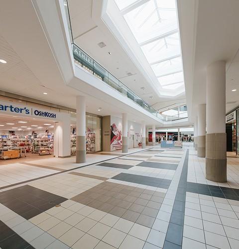 Mall concourse under skylights with a Carter's OshKosh storefront