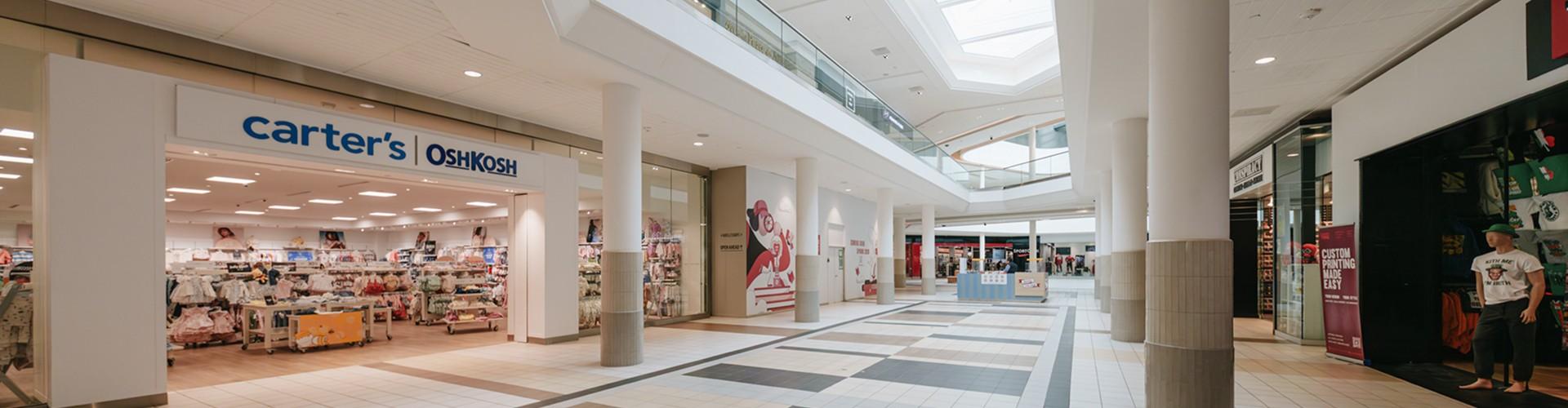 Mall concourse under skylights with a Carter's OshKosh storefront