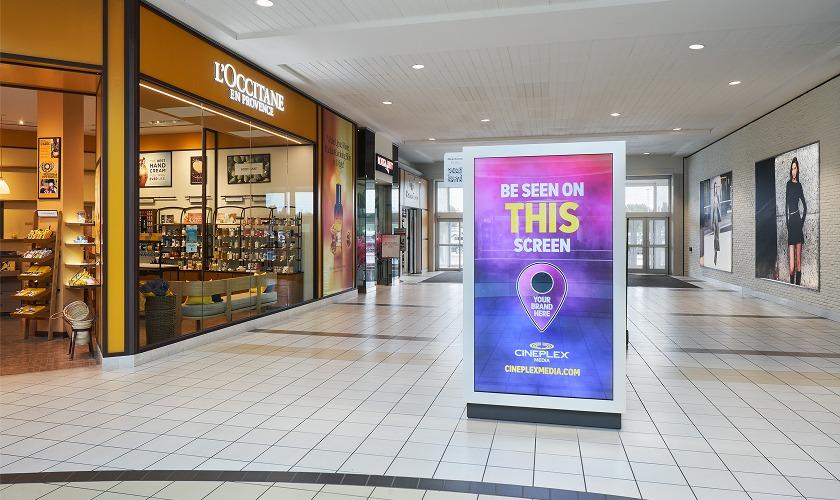 Cineplex Media digital ad screen in a mall concourse near L'Occitane