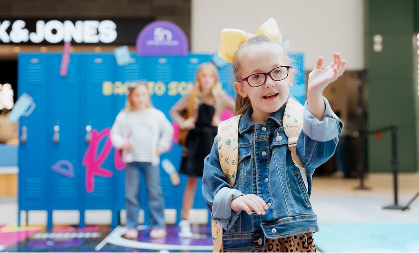 Girl with a backpack at a back-to-school locker photo activation in the mall