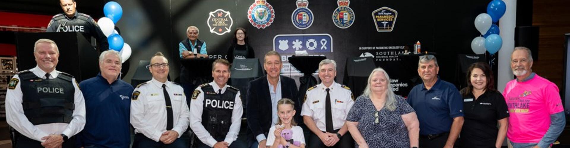 Group of police, fire and paramedic officials posing for a charity event photo