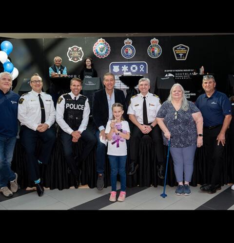 Group of police, fire and paramedic officials posing for a charity event photo
