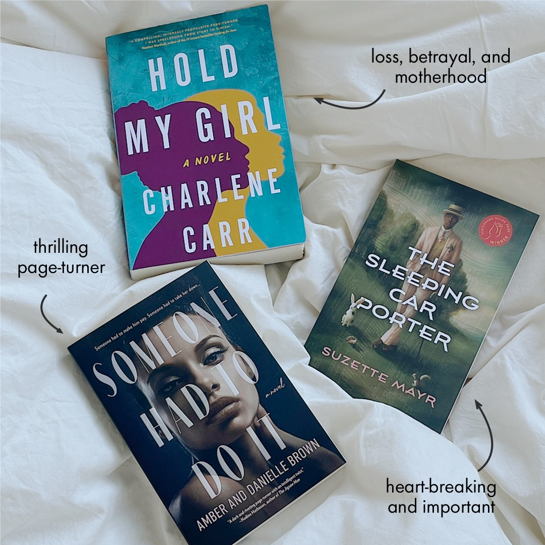 Three different books are laid out on a white duvet.