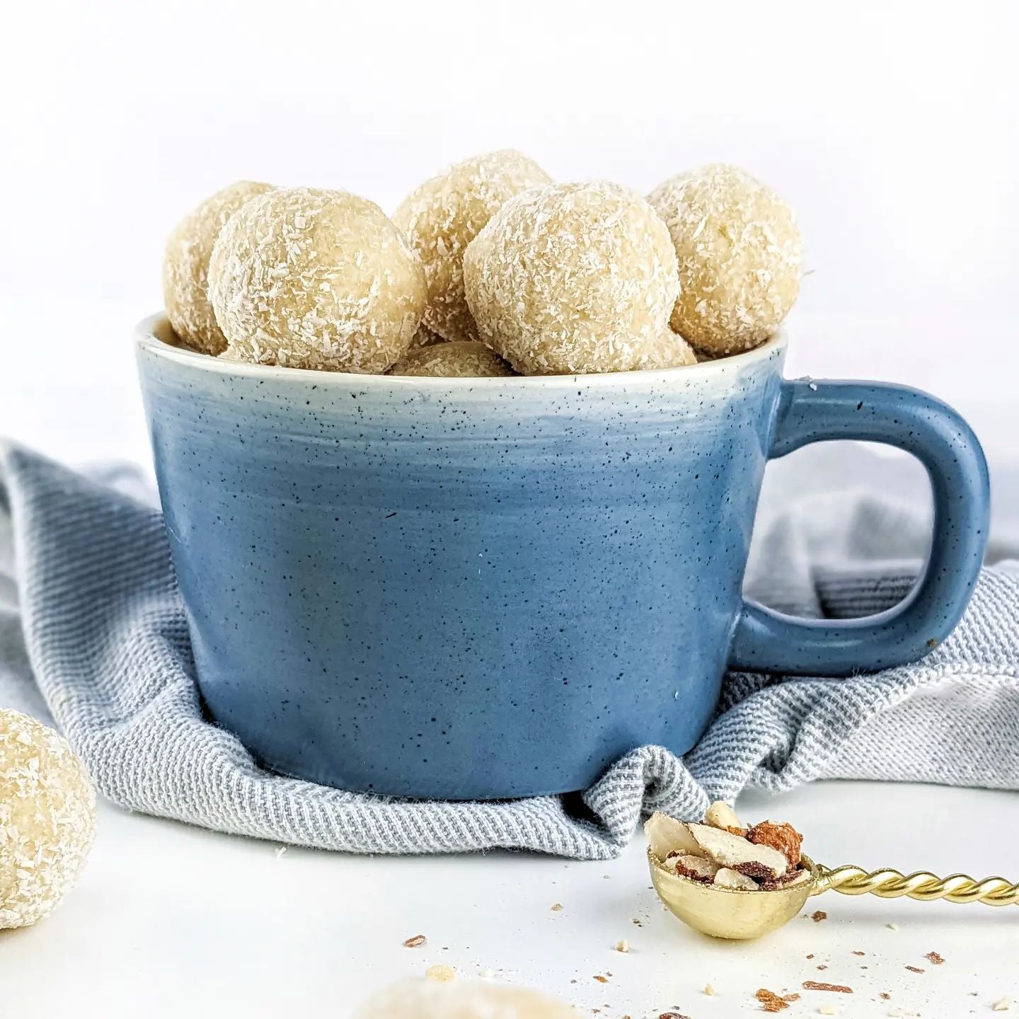 Round cookies from Humble Roots Orangic sit in a light blue mug on a table.