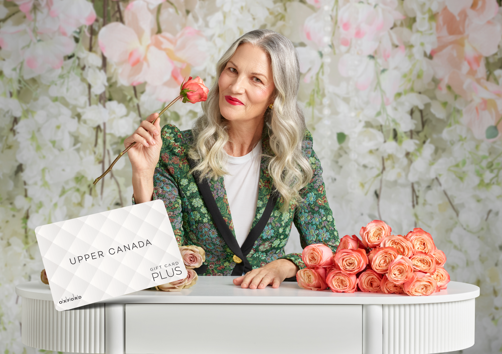 Woman holding a rose in front of an Upper Canada gift card