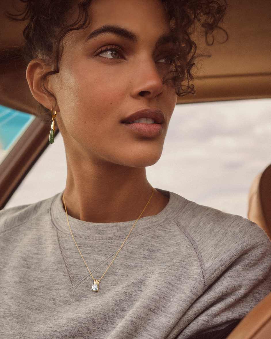Model wearing a grey shirt with a necklace