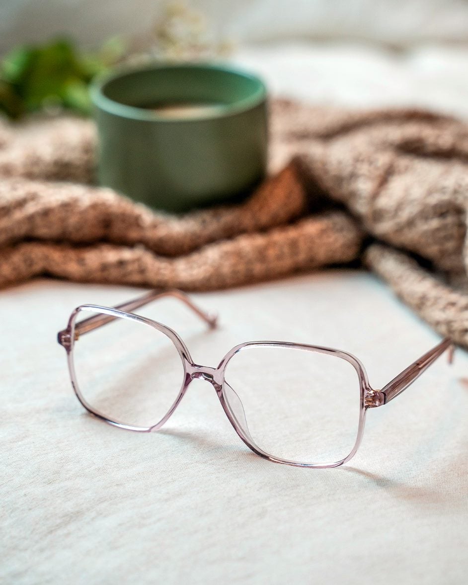 Bronze frame glasses with a cup in the background