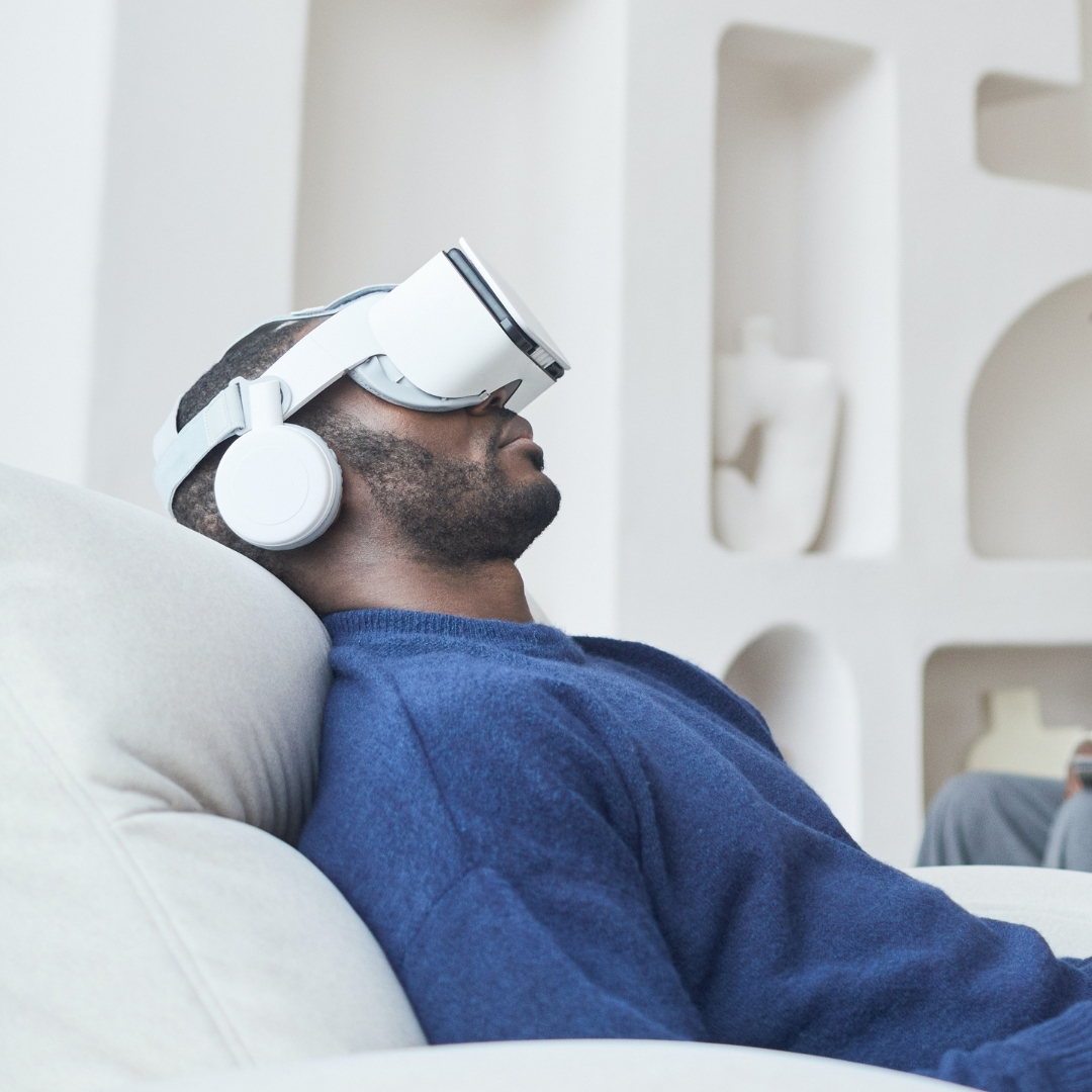 a side view image of a man lying on a couch wearing a virtual reality headset