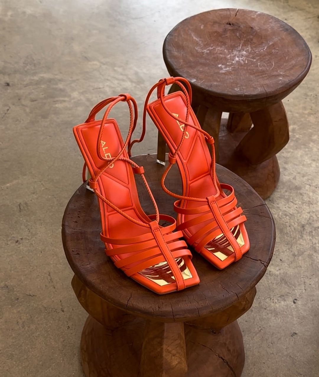 image of orange heeled sandals on a wooden stool