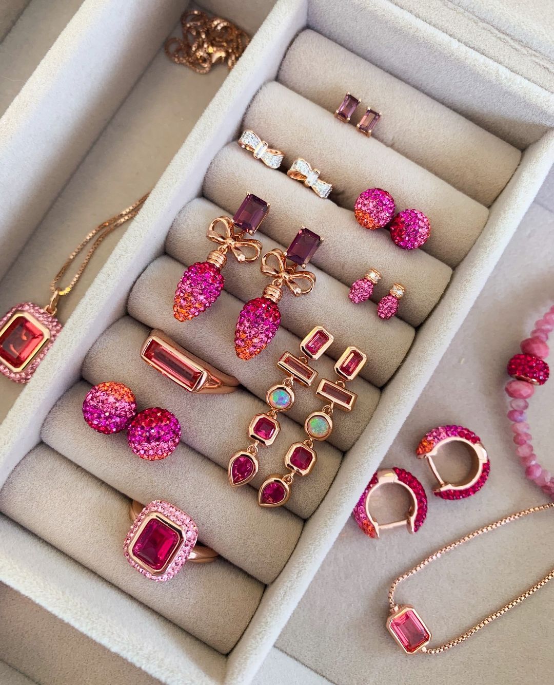 Variety of pink earrings in jewellery holder.