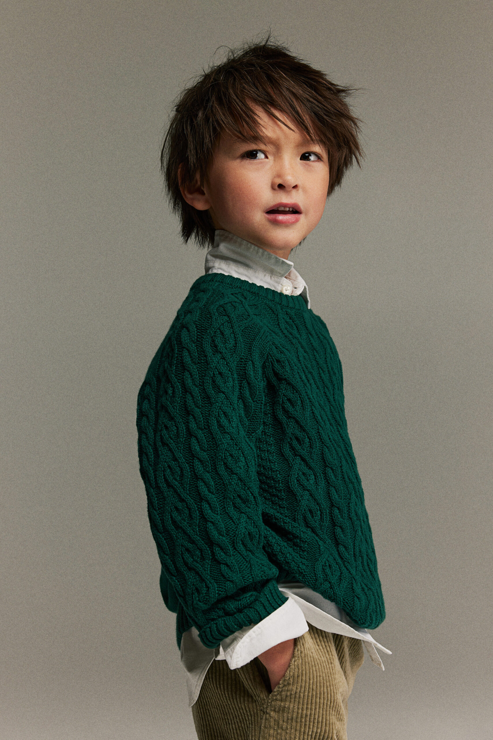Boy wearing forest green knit sweater.