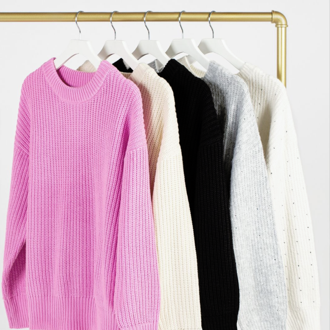 Clothing rack with knit sweaters from Honey