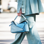 Model is blue two-piece set holding a blue top-handle purse