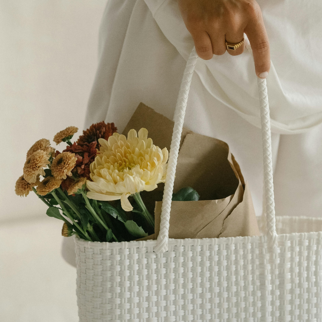 Woman holding basket with flowers in it.