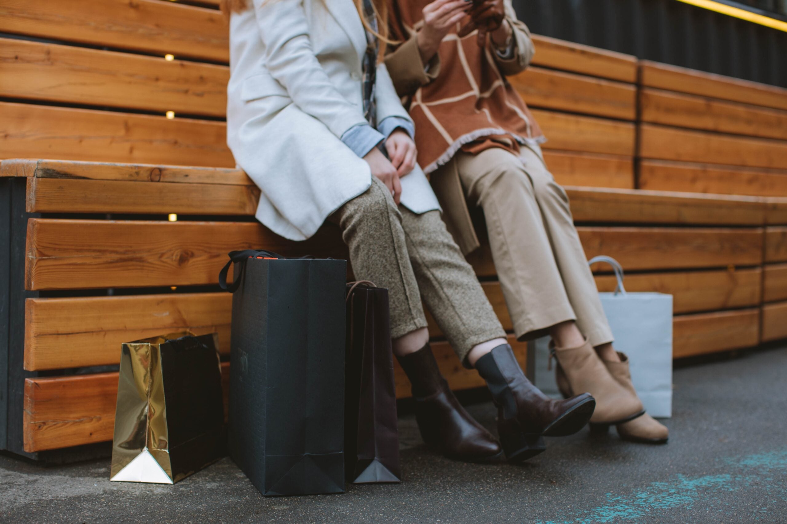 Two people sitting outside with shopping bags